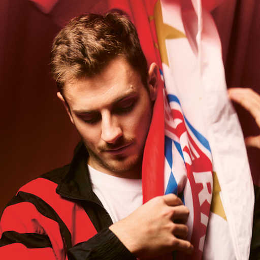 Josip Stanisic greift eine FC Bayern-Fahne.