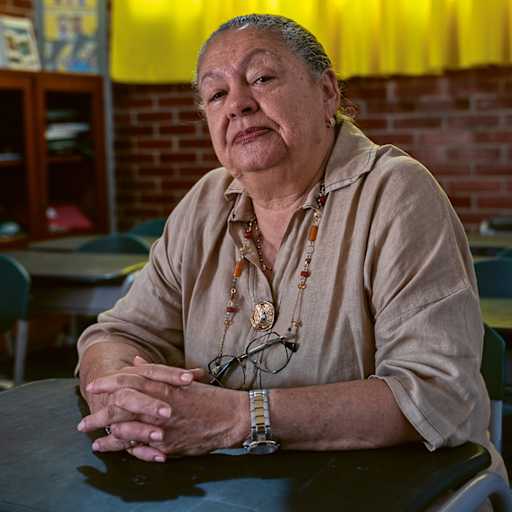 Ana Beatriz Solano (74), ehemalige Grundschullehrerin von Barrancas, sitzt an einem Tisch im Klassenzimmer