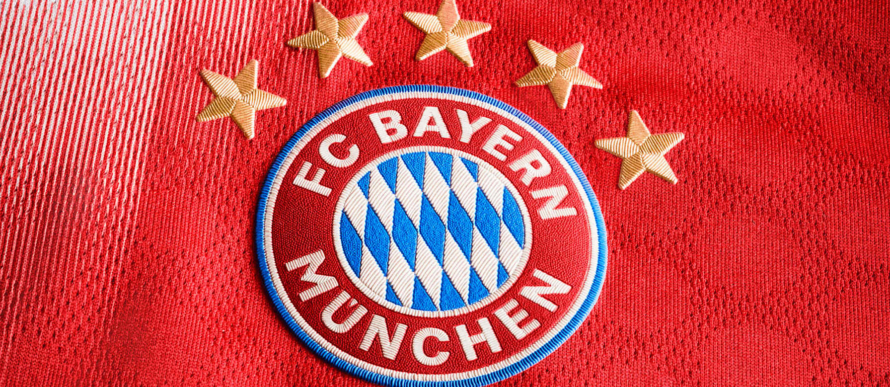 Das FC Bayern-Logo vor einem roten Hintergrund
