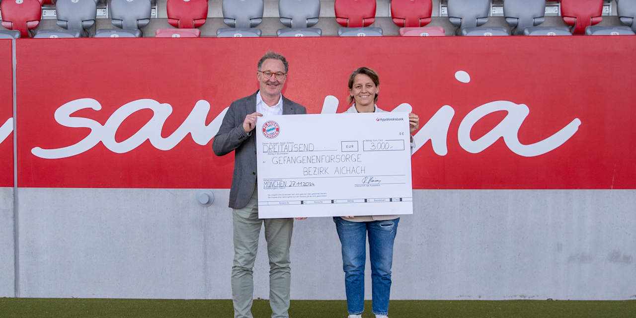 Bianca Rech, Direktorin der FC Bayern Frauen, übergibt einen Spenden-Scheck an den Geschäftsführer des Gefangenenfürsorgevereins Stefan Schrempel.