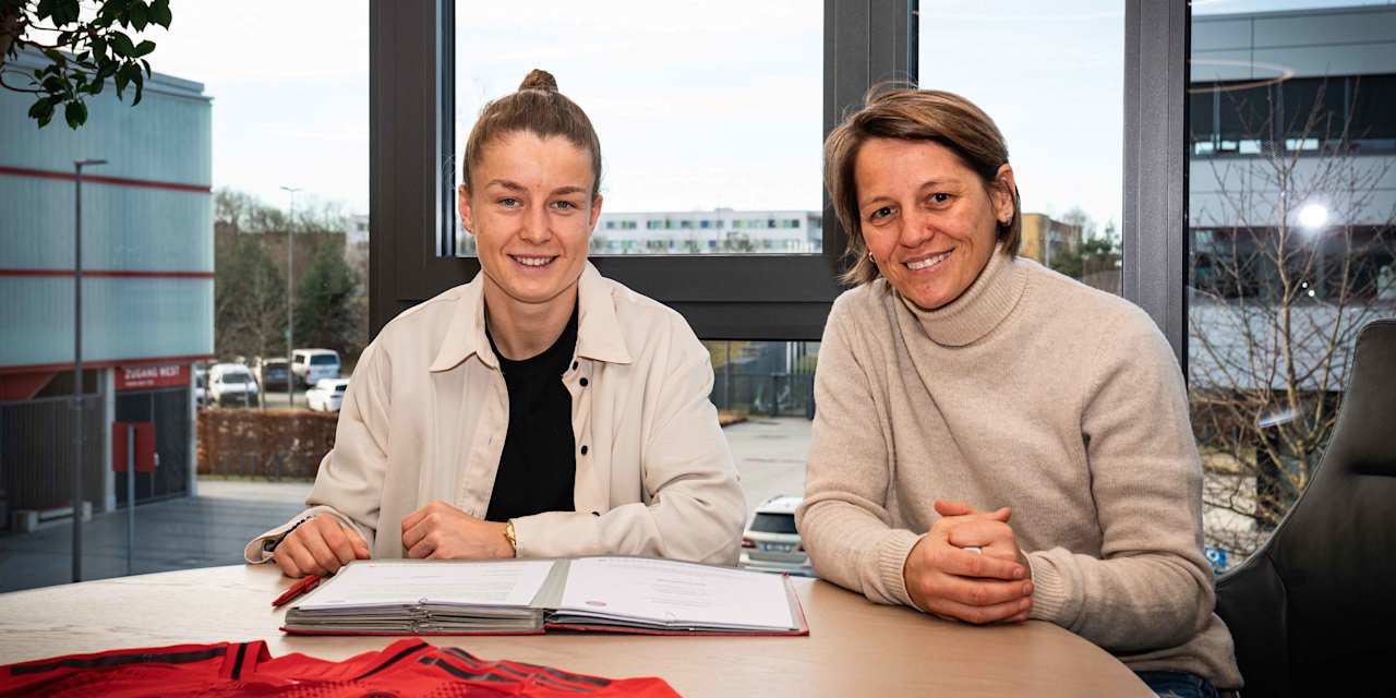 Bianca Rech und Michelle Ulbrich lächeln bei der Vertragsunterschrift in die Kamera.