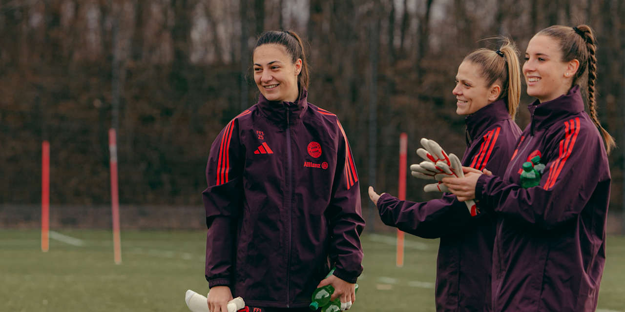 Torhüterin Mala Grohs steht lächelnd neben ihren Teamkolleginnen Anna Wellmann und Ena Mahmutovic auf dem Trainingsplatz.