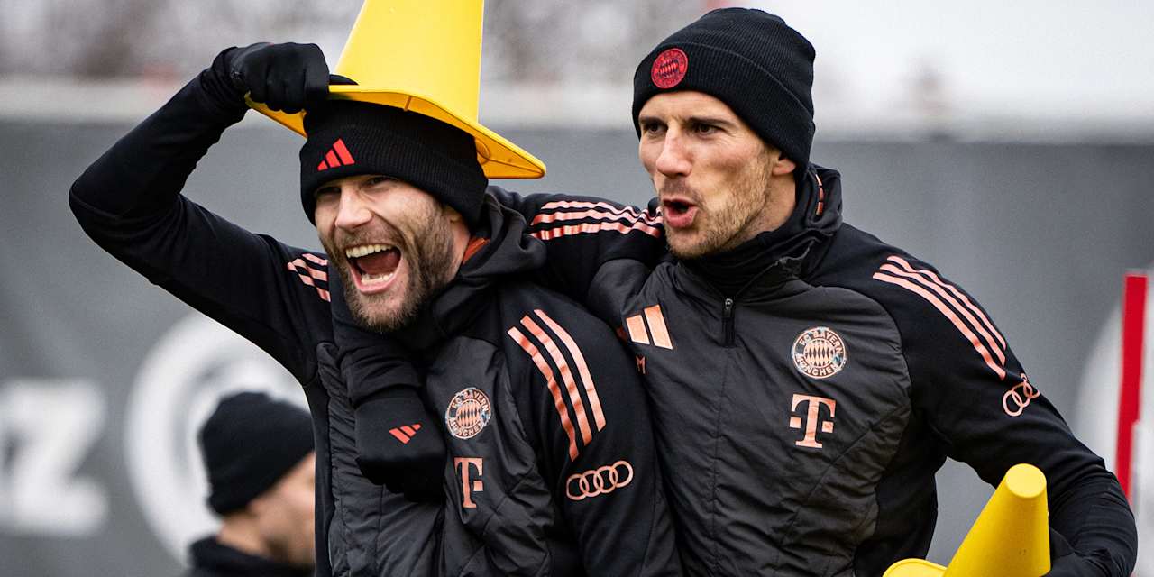 Leon Goretzka setzt Konrad Laimer ein Hütchen auf den Kopf und beide Spieler lachen im Training des FC Bayern