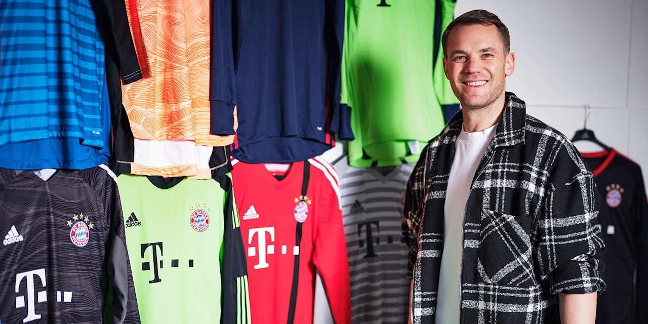 Manuel Neuer steht vor seinen Trikots