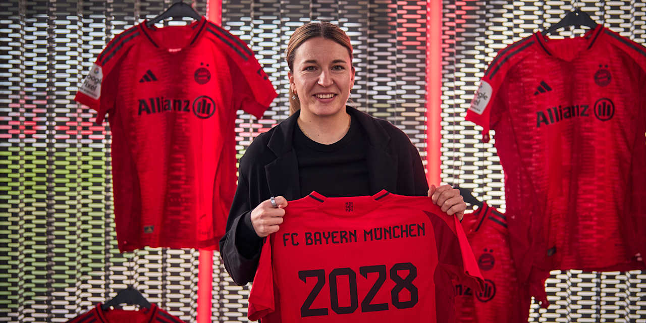 Barbara Dunst hält stehend das Trikot mit ihrer Vertragslaufzeit in die Höhe.