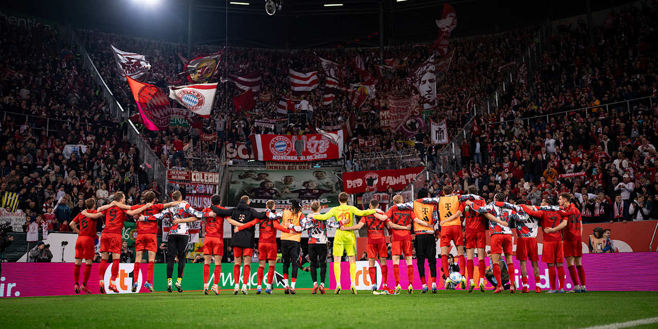 Die FC Bayern-Spieler stehen Arm-in-Arm vor der Fankurve beim Auswärtsspiel in Augsburg