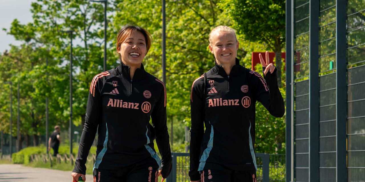 Momoko Tanikawa und Pernille Harder laufen lächelnd zum Trainingsplatz und zeigen ein Peace-Zeichen.