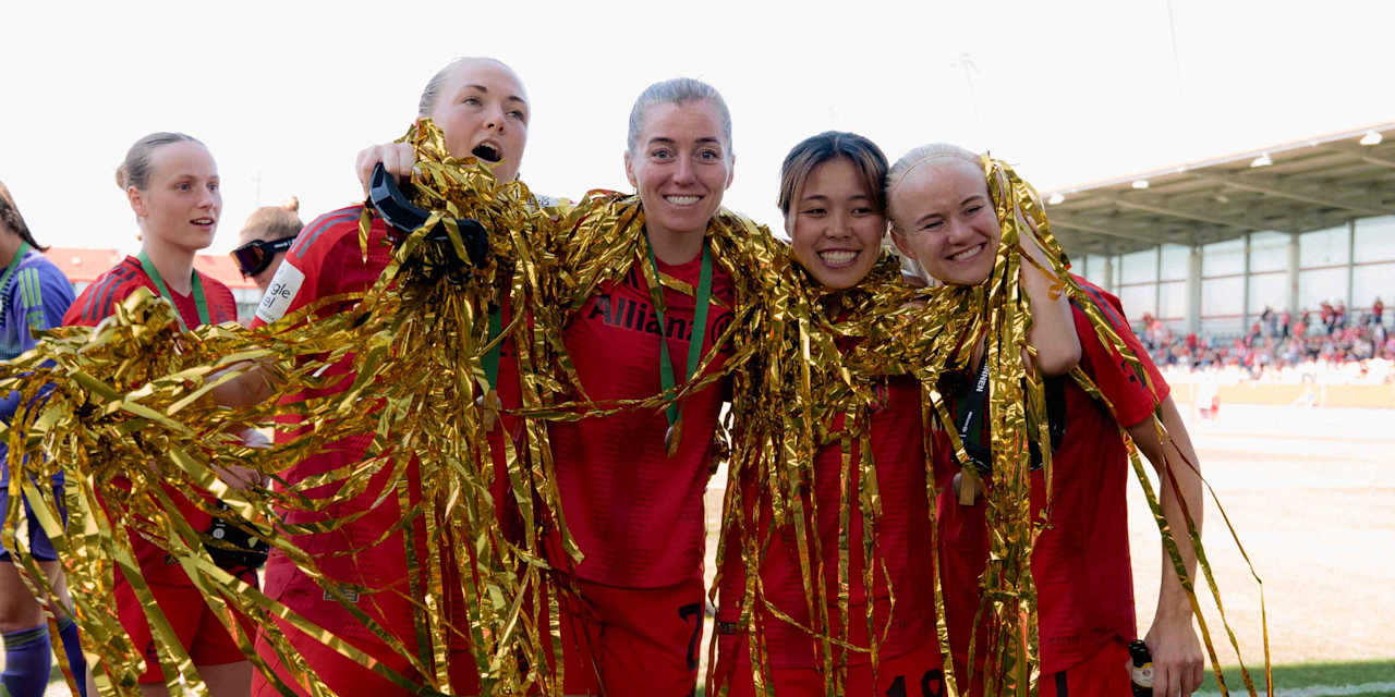 Magdalena Eriksson, Linda Sembrant, Momoko Tanikawa und Pernille Harder von den FC Bayern Frauen stehen Arm in Arm mit Lametta um den Hals auf dem Platz und lächeln in die Kamera.