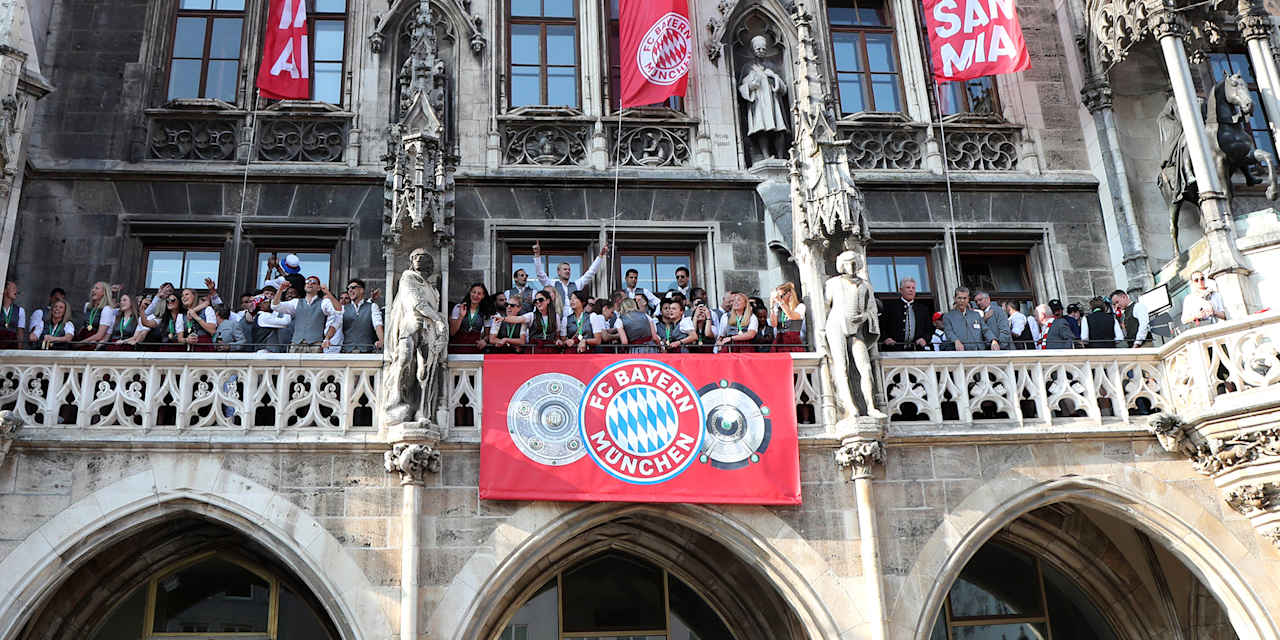 Frauen- und Herrenmannschaft grüßen 2023 vom Rathausbalkon mit den Trophäen