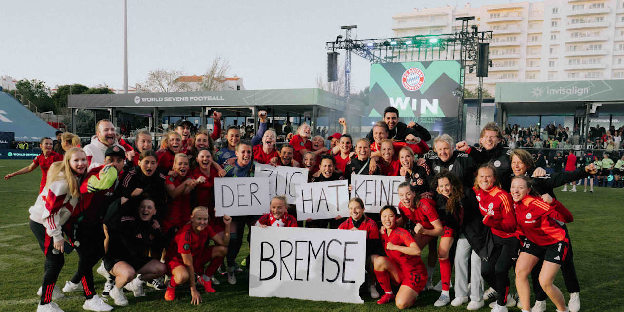 Die FC Bayern Frauen jubeln auf einem Gruppenfoto mit Schildern in der Hand, auf denen "Der Zug hat keine Bremse" steht.