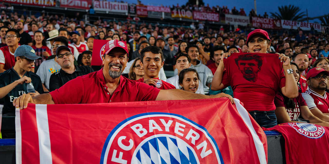 FC Bayern Fans in den USA halten eine FCB-Fahne hoch