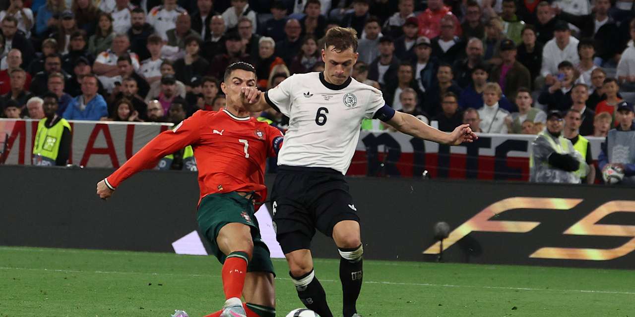 Joshua Kimmich (Germany) on the ball being tackled by Cristiano Ronaldo (Portugal).