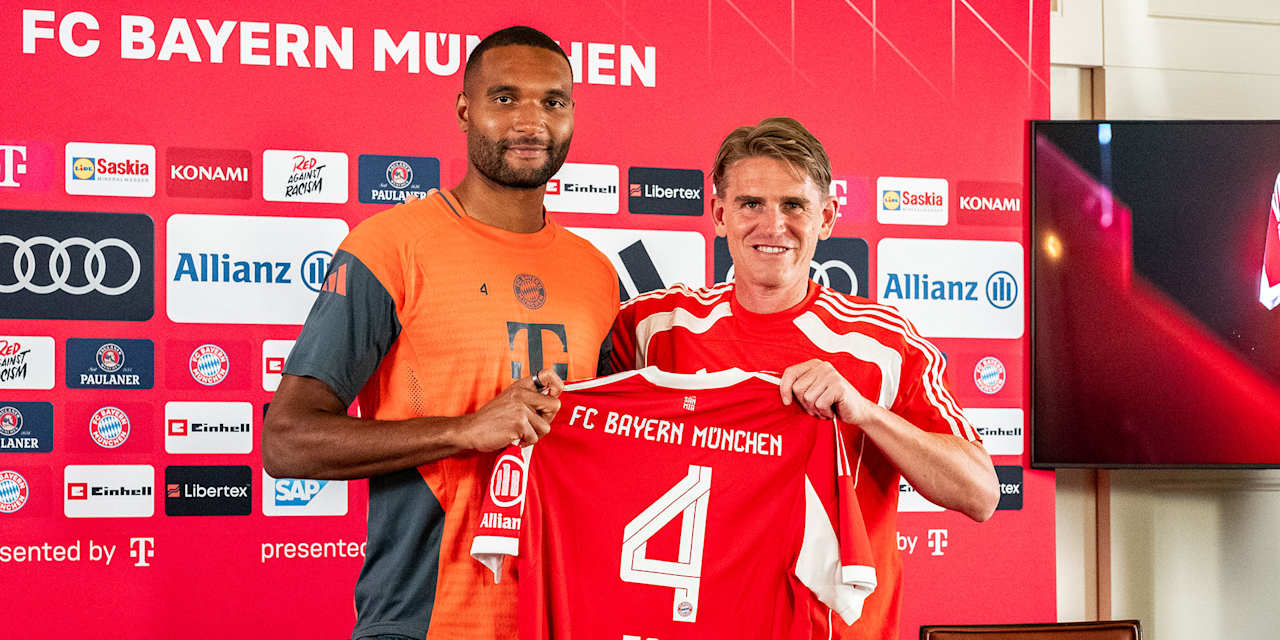 Jonathan Tah und Christoph Freund halten ein FCB-Trikot mit der Rückennummer 4 hoch