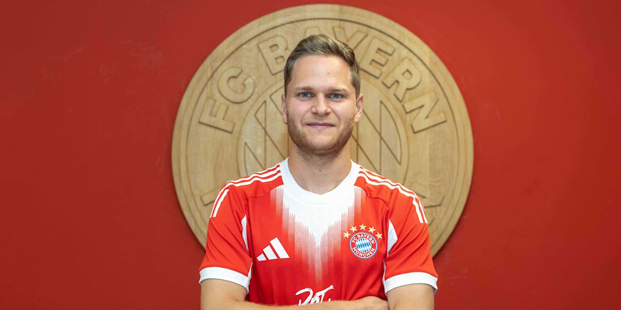 Beno Schmitz posiert vor einem FC Bayern Wappen.