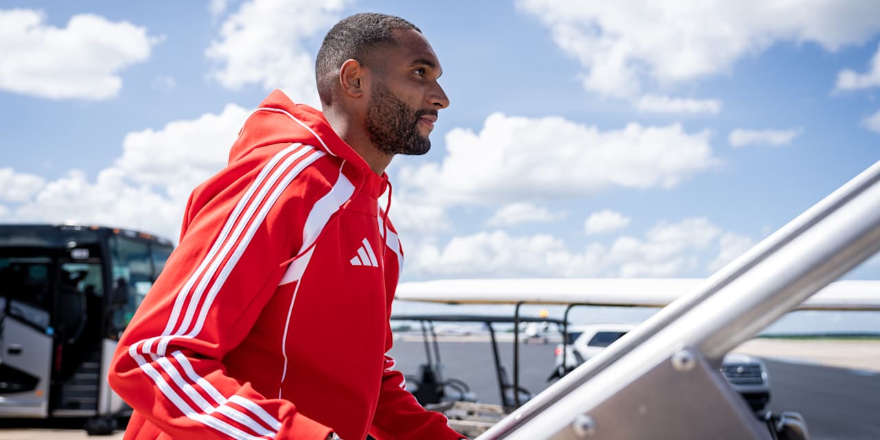Jonathan Tah besteigt in der roten Teamline des FC Bayern ein Flugzeug