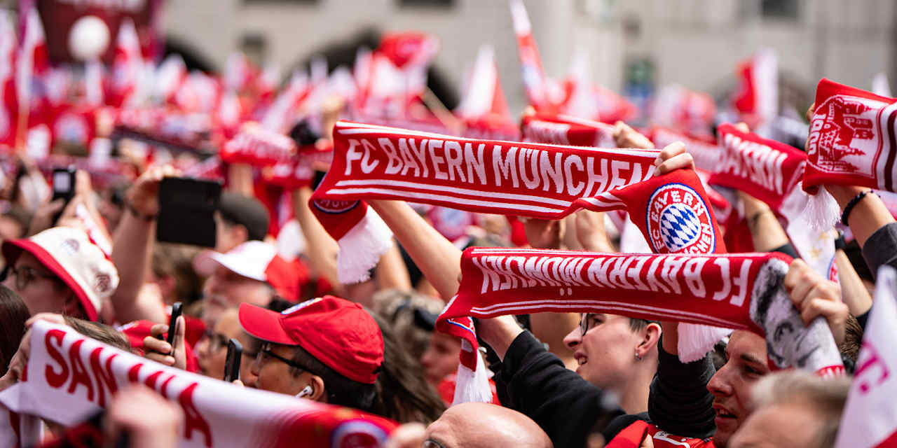 FC Bayern fans hold up their scarves at the title celebrations on Marienplatz.