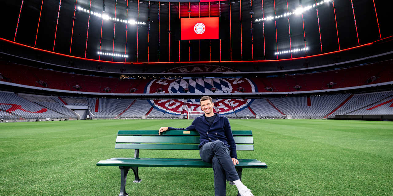 Thomas Müller sits in the Allianz Arena on a park bench on the pitch.