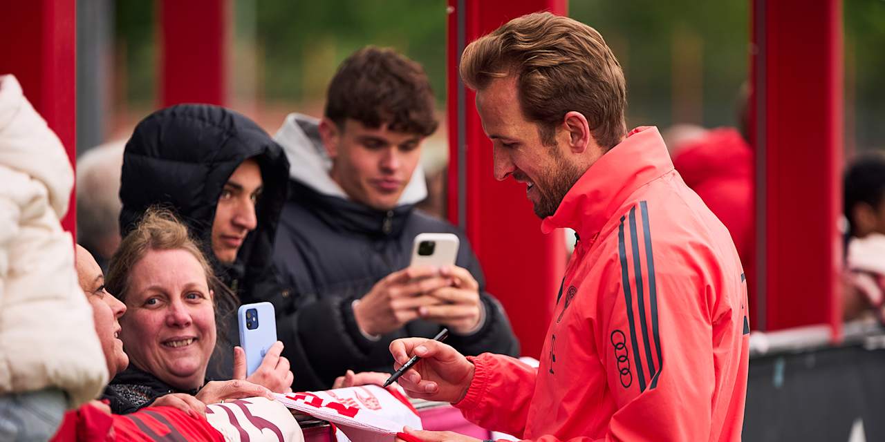 Harry Kane signs fans' shirts at an FC Bayern open training session
