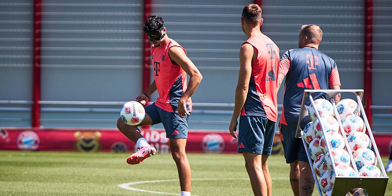 Aleksandar Pavlovic jongliert im Training des FC Bayern mit einem Ball und trägt eine Gesichtsmaske