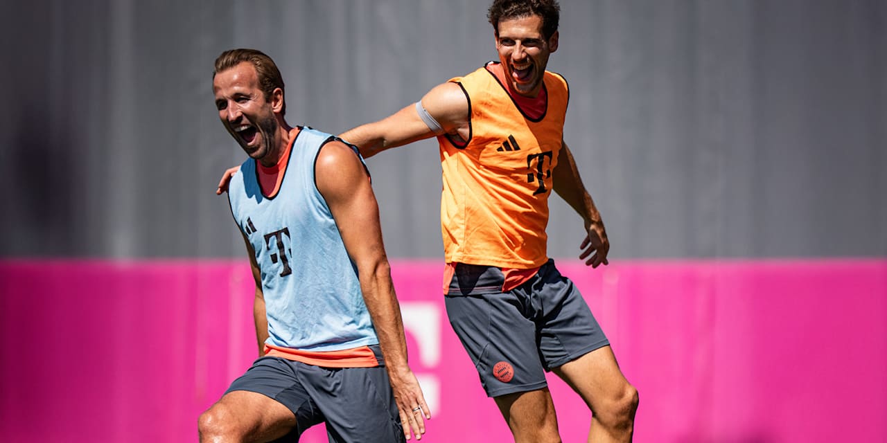Harry Kane und Leon Goretzka lachend beim Warmlaufen im Training des FC Bayern vor dem Pokalspiel in Wiesbaden.