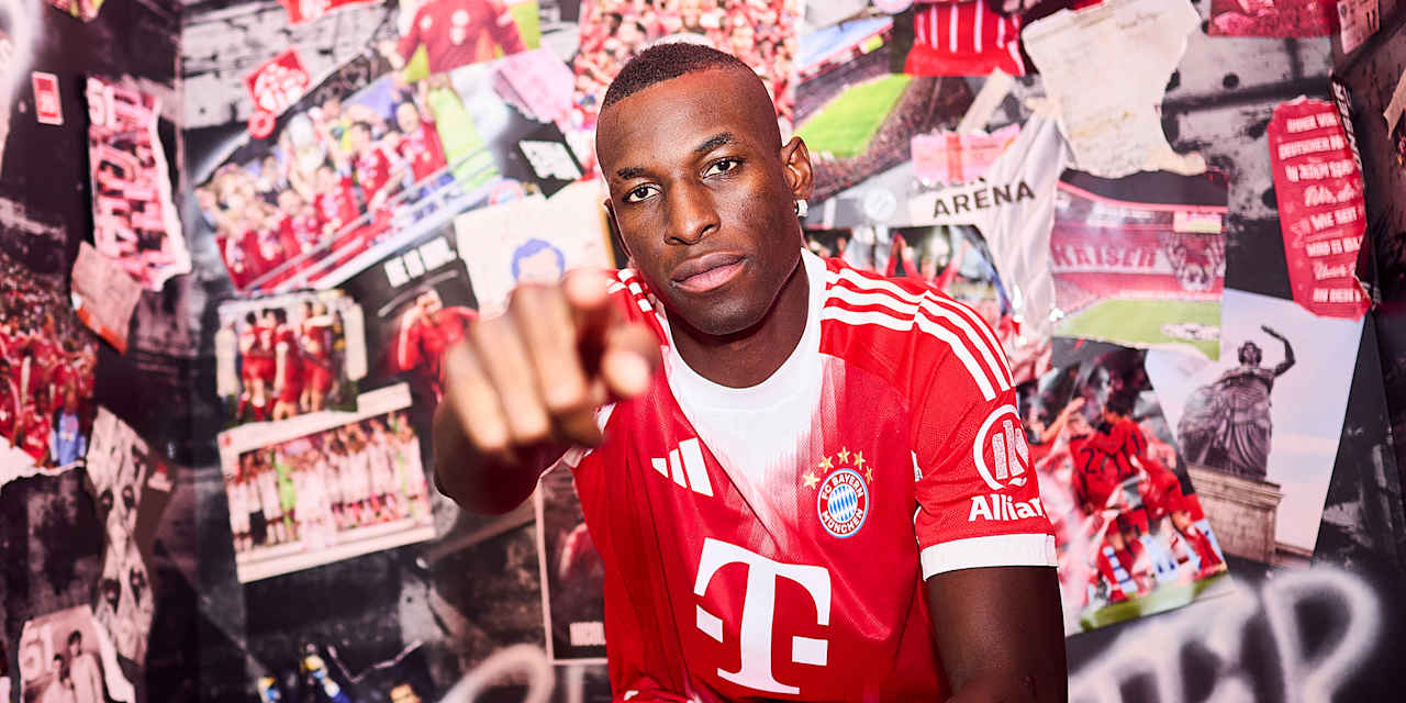 Nicolas Jackson trägt ein FC Bayern Trikot und zeigt mit dem Finger in die Kamera