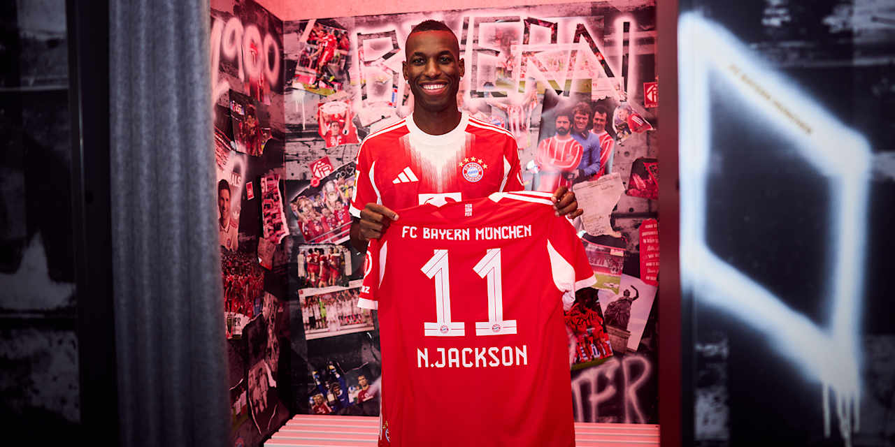 Nicolas Jackson hält ein FC Bayern Trikot mit der Nummer 11 und N. Jackson
