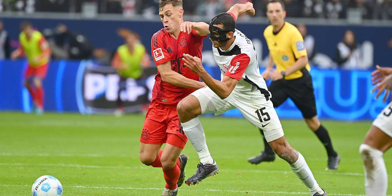 Joshua Kimmich im Zweikampf mit einem Frankfurter Gegenspieler mit Gesichtsmaske.