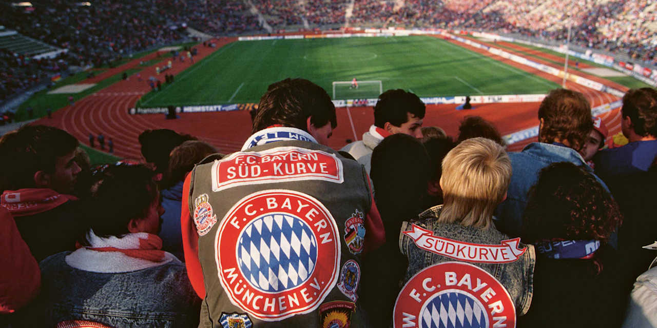 Fans des FC Bayern mit einer Kutte sitzen im Olympiastadion