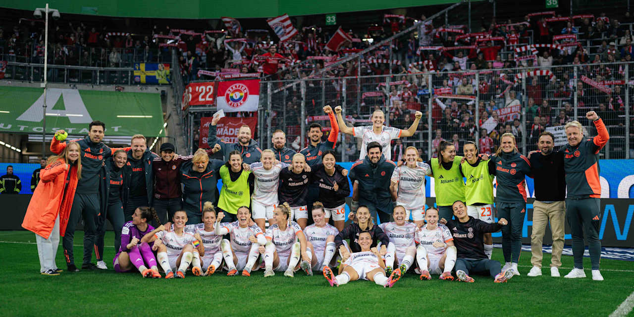 The celebrating team in a group photo in front of the FC Bayern fan section.