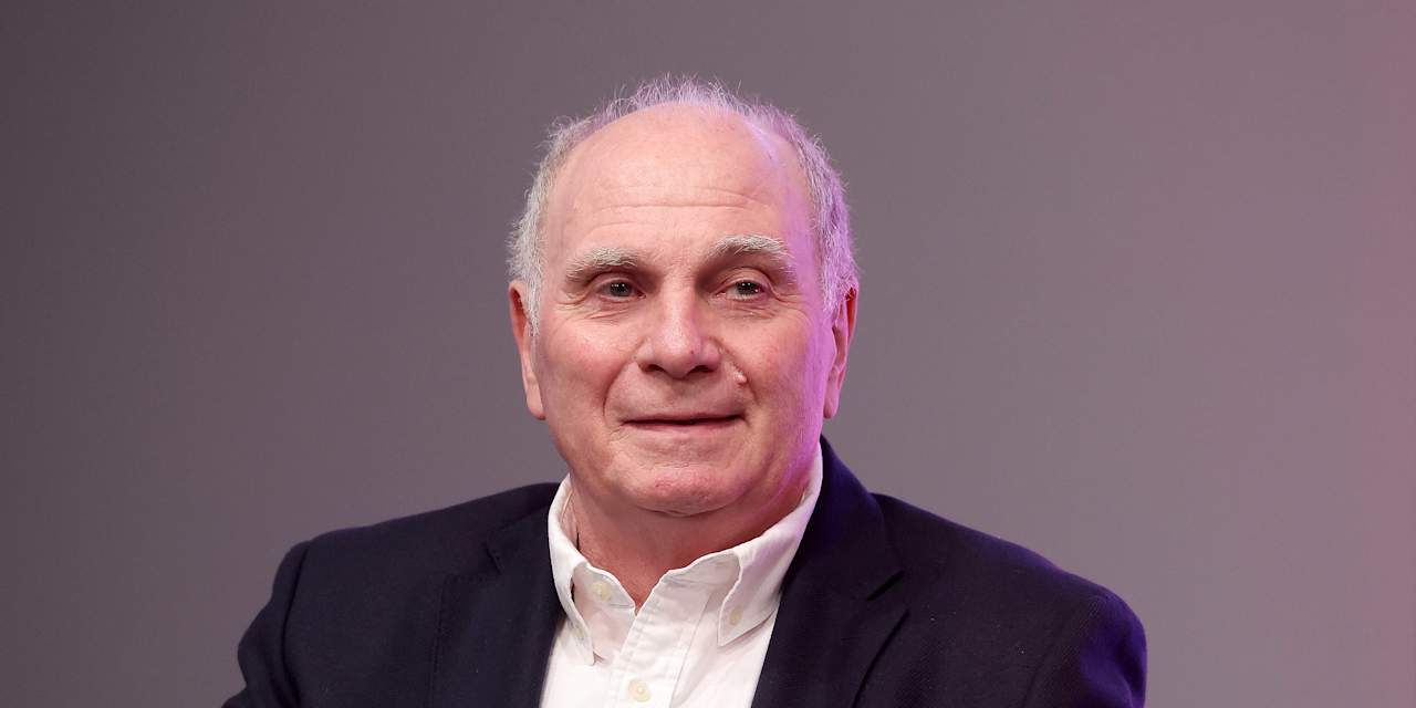 Uli Hoeneß lächelt im Anzug in die Kamera