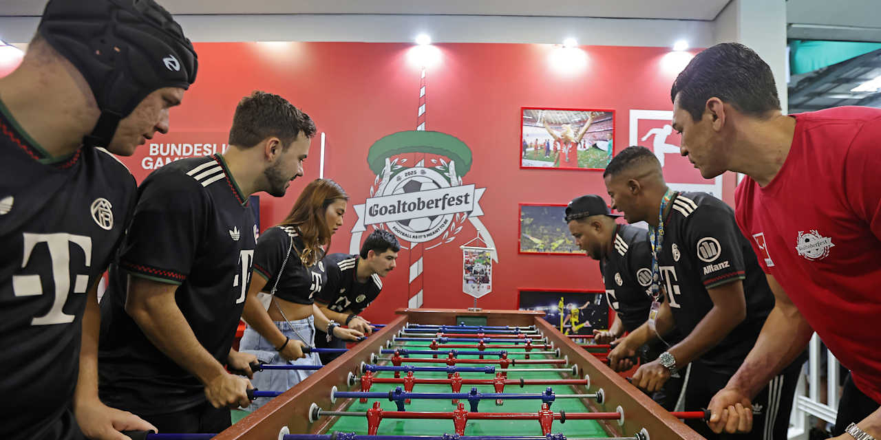 Lúcio spielt in Brasilien Tischkicker mit Personen in Bayern-Trikots