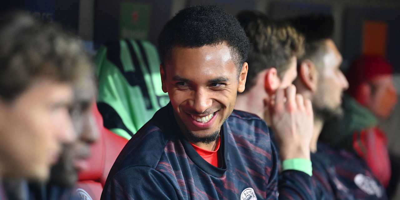 Vincent Manuba lächelt auf der Bank während des Champions League-Spiels des FC Bayern.