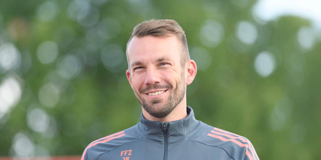 Jérôme Reisacher lächelnd auf dem Weg zum Training am FC Bayern Campus.