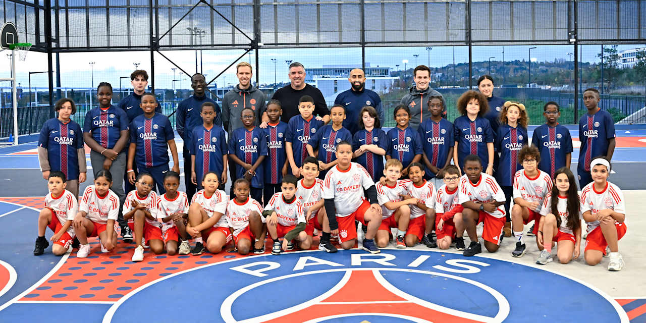 Jugendliche mit Trikots von PSG und FC Bayern gemeinsam mit den Coaches, darunter Roy Makaay, posieren für ein Foto
