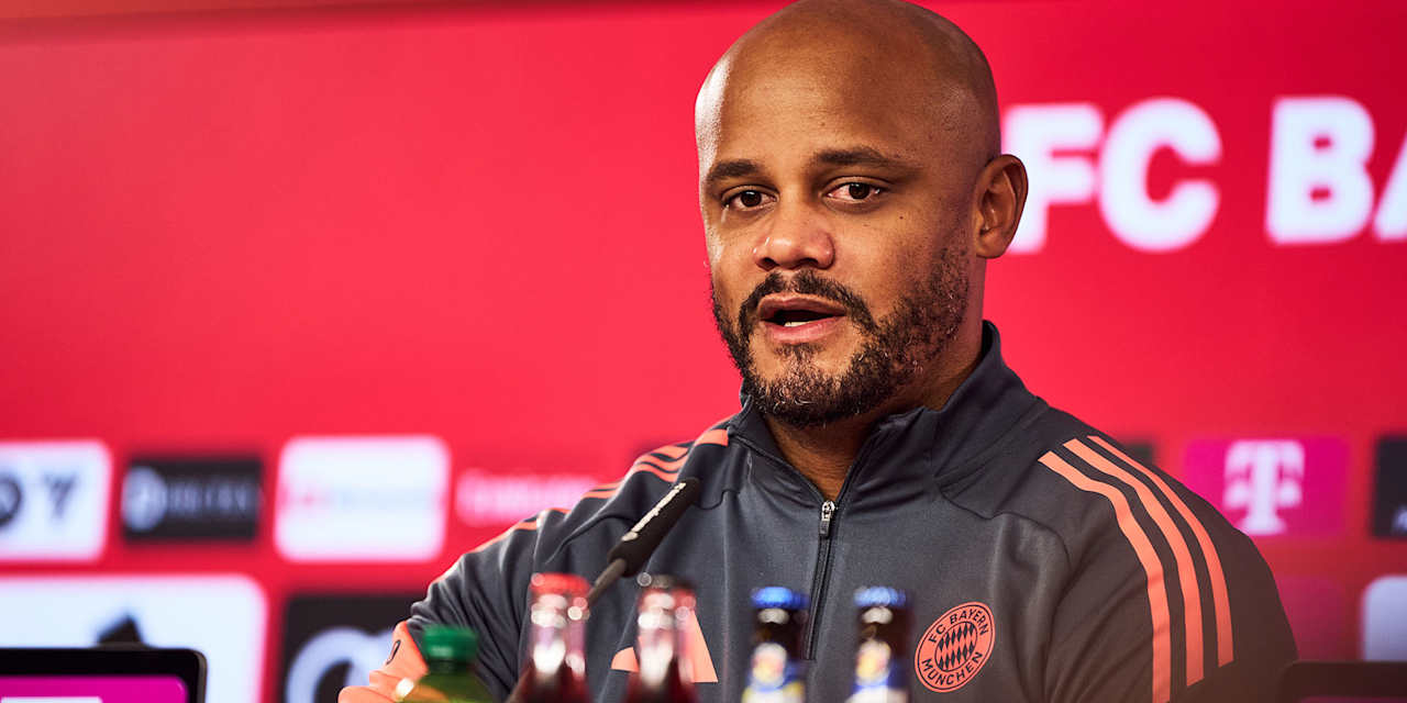 Durch den Bildschirm einer Videokamera sieht man Vincent Kompany auf dem PK-Podium.