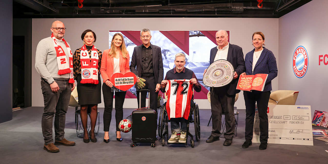 Teilnehmer der Podiumsdiskussion halten Stücke aus dem FC Bayern Erinnerungskoffer hoch