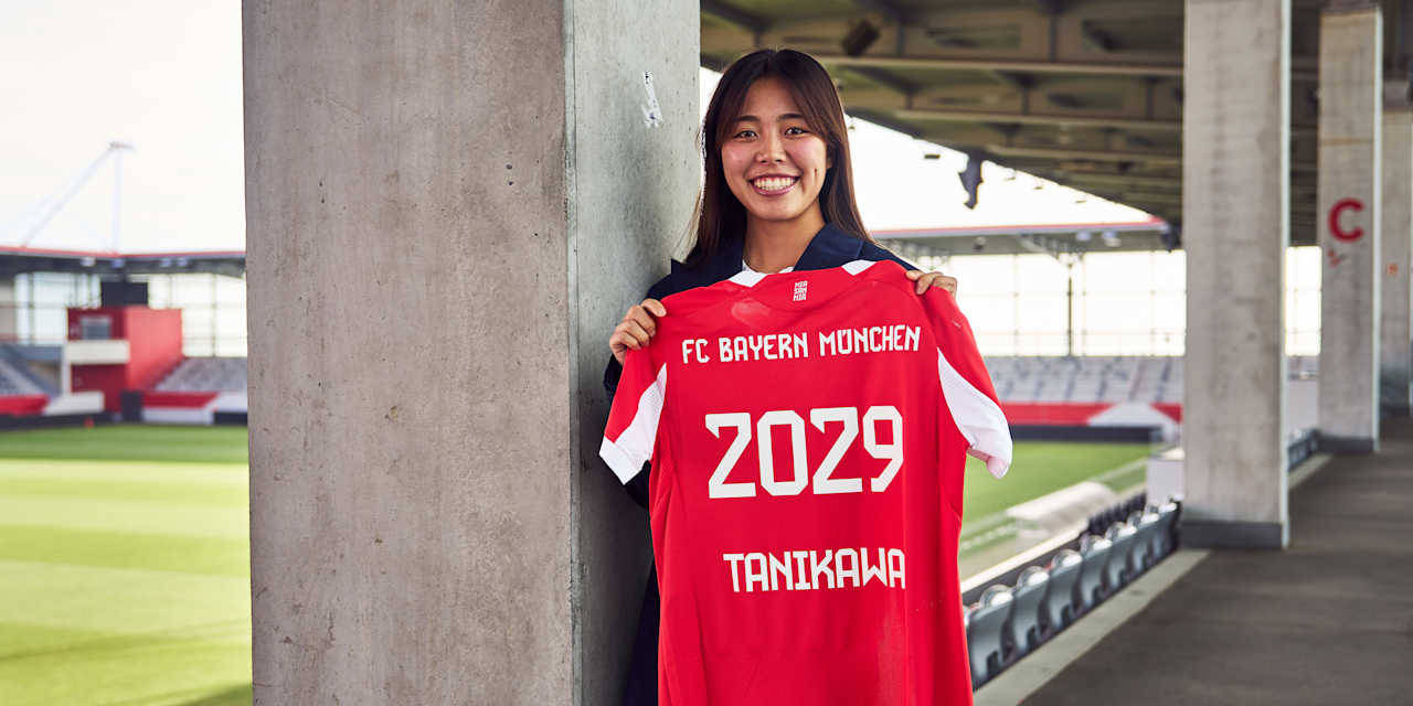 Momoko Tanikawa holds up her Bayern jersey with 2029 printed on the back.