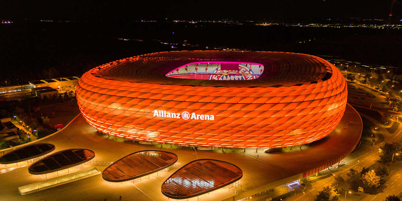 Fassade der Allianz Arena erstrahlt bei Nacht in Orange.
