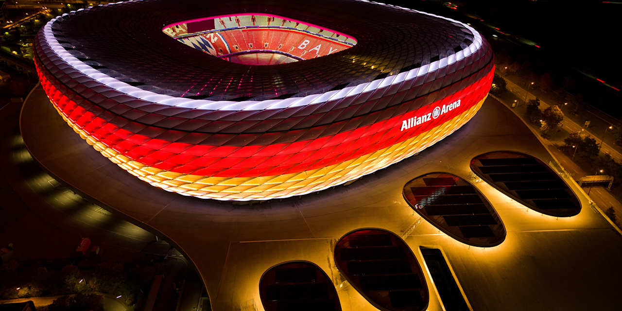 Allianz Arena leuchtet bei Nacht in den deutschen Farben schwarz, rot, gold