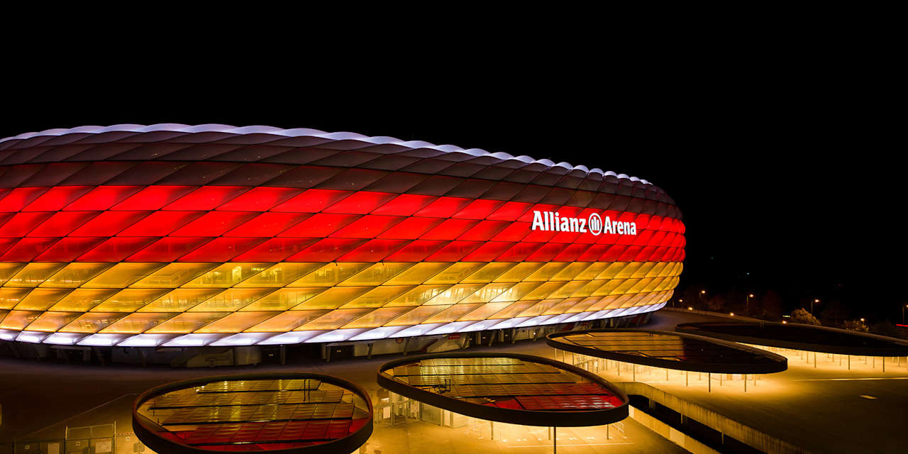 Die Münchner Allianz Arena bei Nacht in den Farben schwarz, rot und gold.