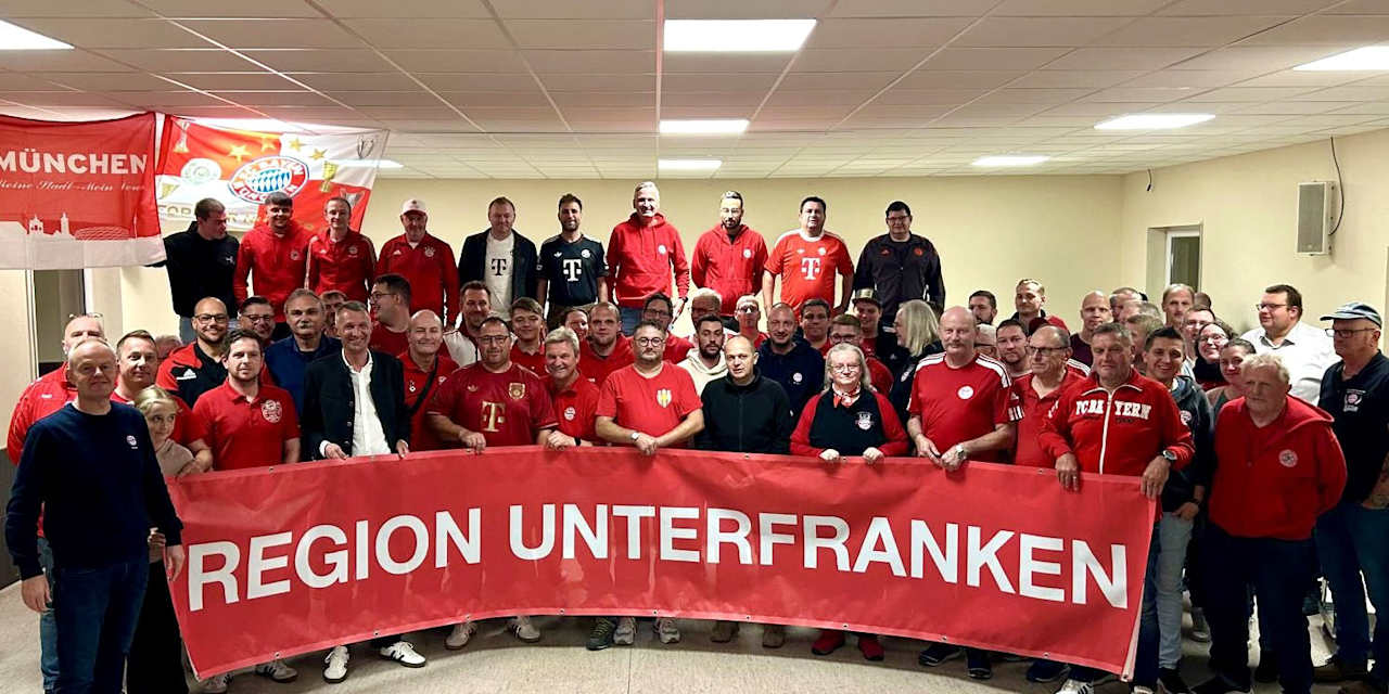 Bayernfans haben sich aufgereiht für die Kamera mit einem großen Banner "Region Unterfranken"