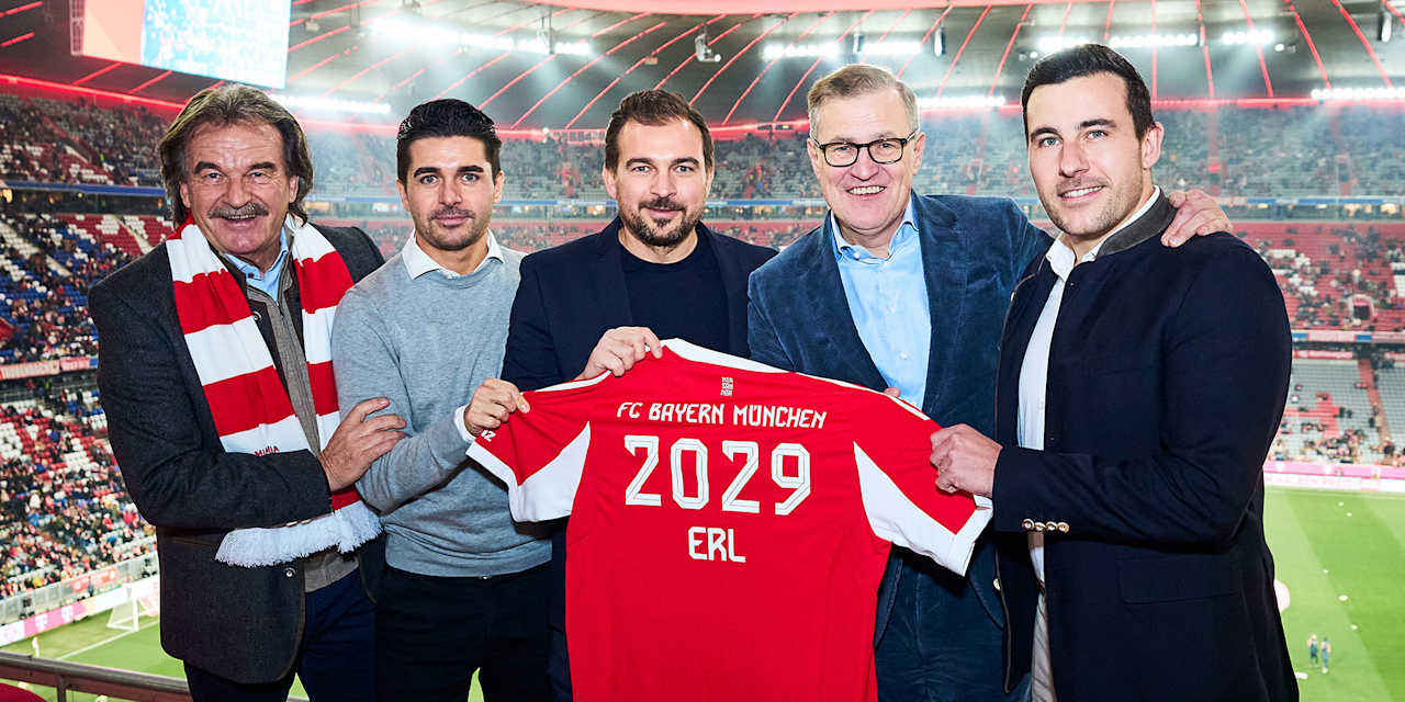 Jan-Christian Dreesen und Vertreter von ERL halten ein FC Bayern-Trikot mit dem Schriftzug 2029 ERL.