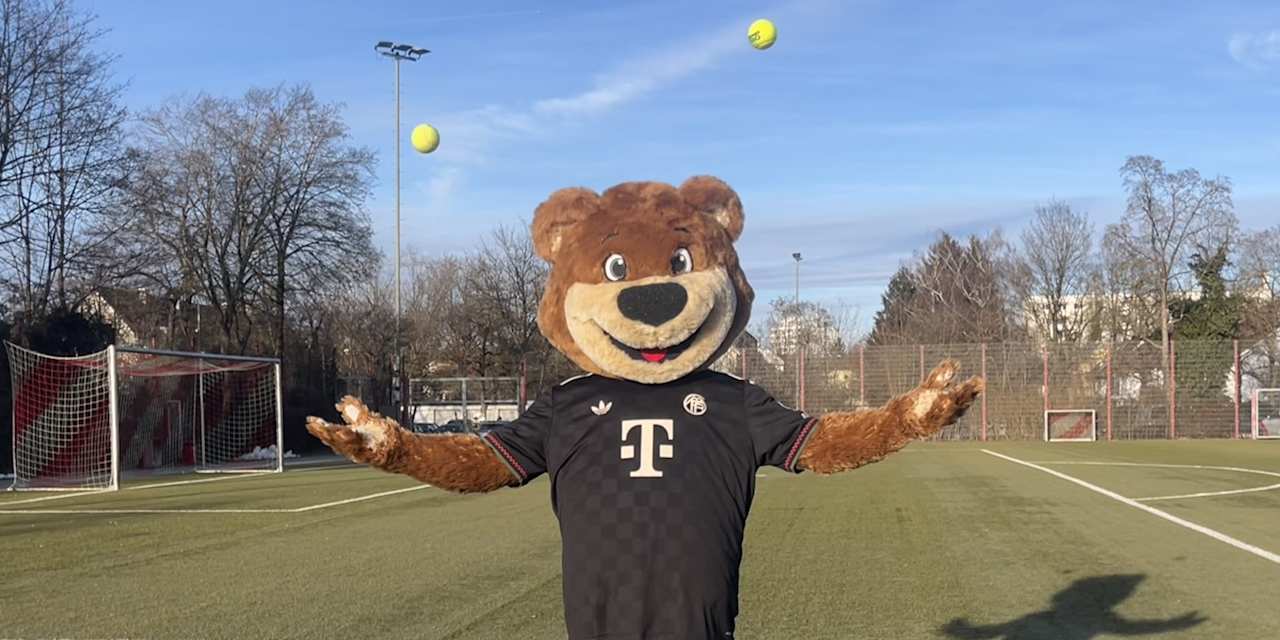 Berni steht auf dem Kunstrasenplatz und wirft mit jeder Hand einen Tennisball hoch.