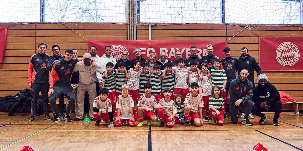 Gruppenfoto von Schulkindern mit FC Bayern und Sporting Lissabon Trikots