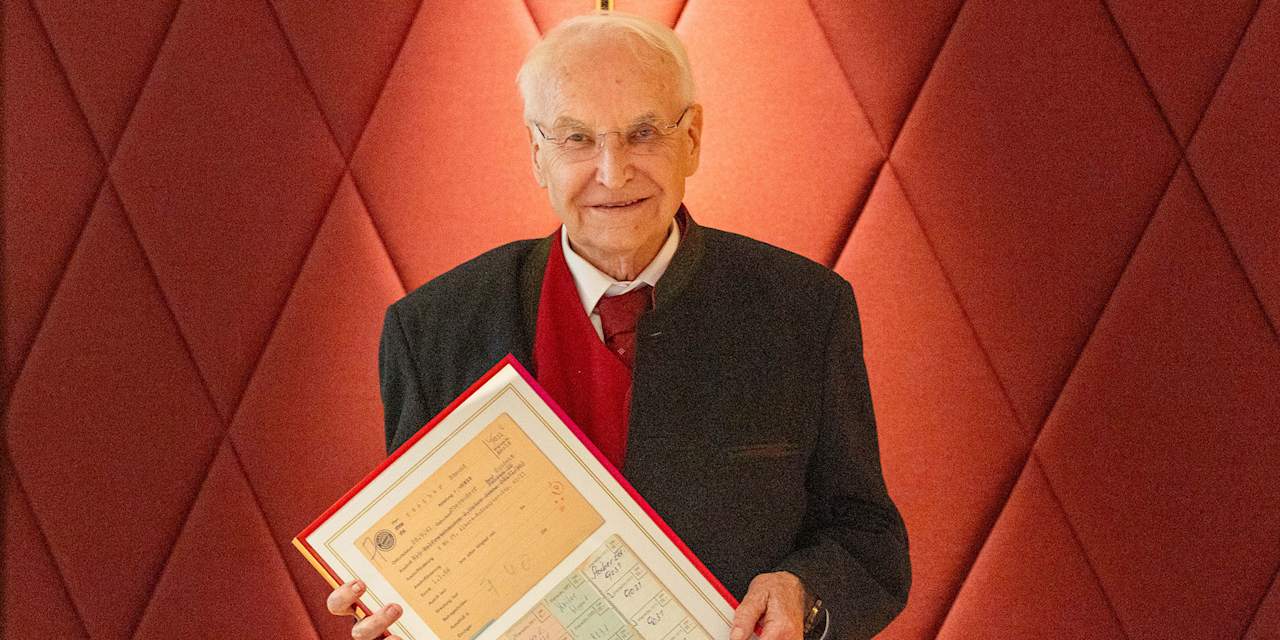 Edmund Stoiber hält eine Urkunde in der Hand