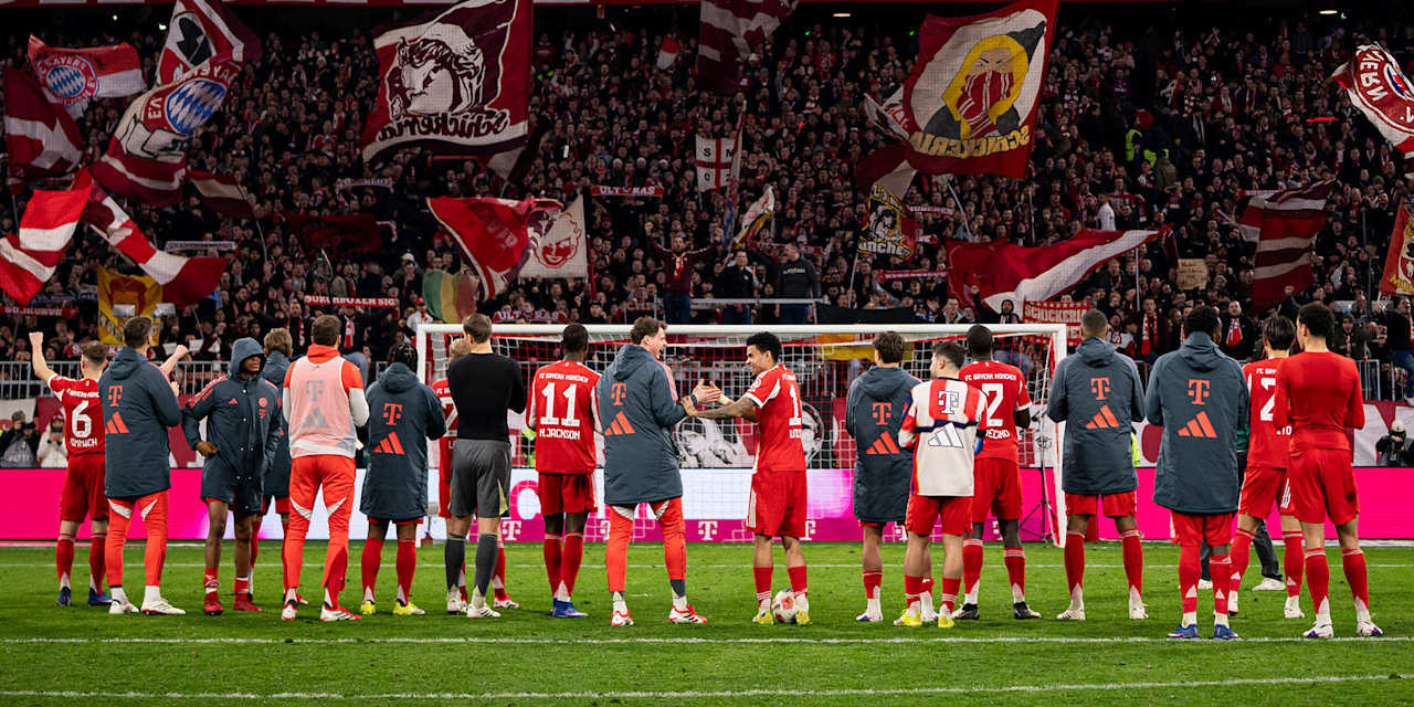 Spieler des FC Bayern jubeln mit den Fans vor der Südkurve.