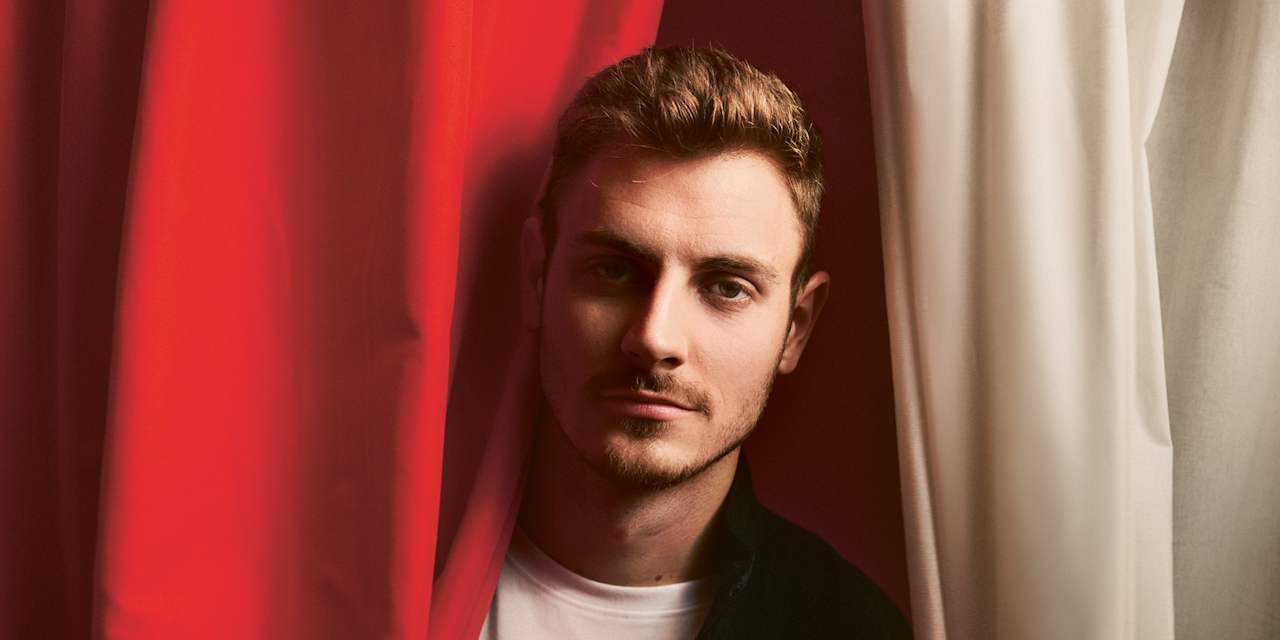 Josip Stanisic zwischen einem rot-weißen Vorhang