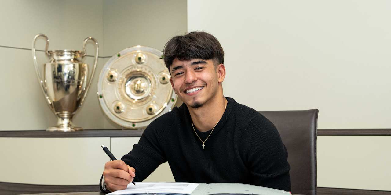 Maycon Cardozo hält bei der Vertragsunterschrift lächelnd einen Stift in der Hand.