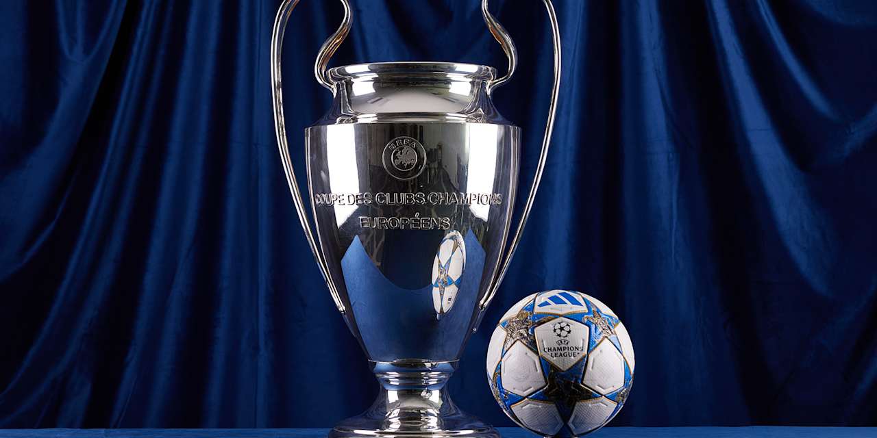 Champions League-Pokal und Ball vor blauem Hintergrund