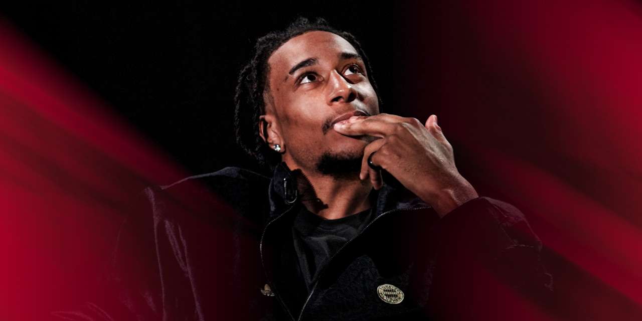 Michael Olise in einem schwarzen Oberteil blickt nach oben.